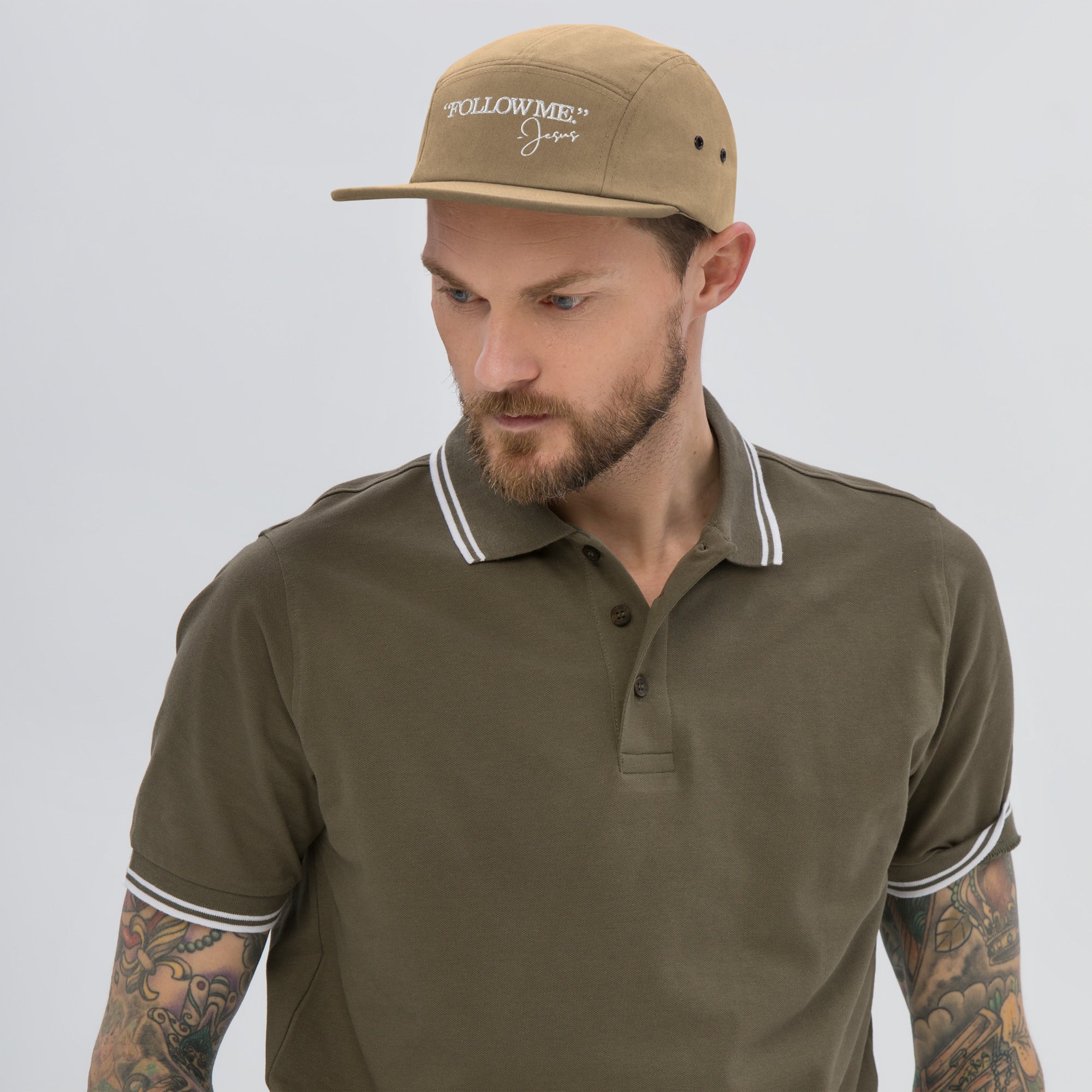 Man wearing a brown cap and matching polo shirt on a gray background